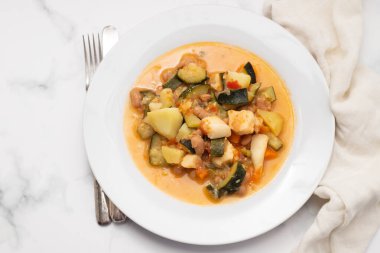 Gri tabakta sebzeli ve soslu kalamar.