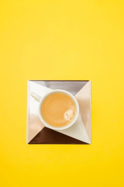 明るい黄色の紙の上にコーヒーをのせると — ストック写真