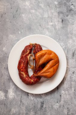 two smoked sausages on white small dish on ceramic