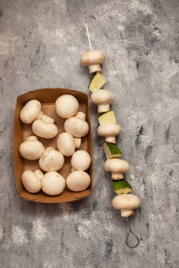 fresh mushrooms champinion in box on gray