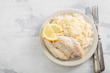 Kızarmış balık filetosu ve kaynamış beyaz pirinç.