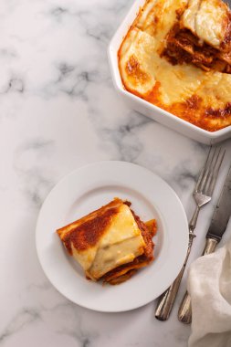 Seramik tabakta fırında pişirilmiş et ve domates soslu taze lazanya. Ev yapımı bolonez lazanyası..