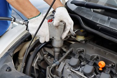 Otomobil tamirhanesinde motor sürgüsünü sıkılaştırmak için torku ingiliz anahtarı torku olan tamircinin eli; otomotiv servisi endüstriyel arka planı