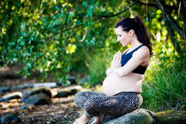 Zwangere vrouw beoefenen van yoga op het strand — Stockfoto