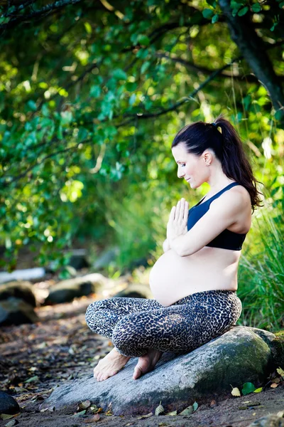 Donna incinta che pratica yoga vicino alla spiaggia — Foto Stock