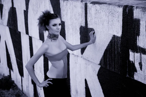 Futuristic young woman near graffiti wall, monochrome — Stock Photo, Image