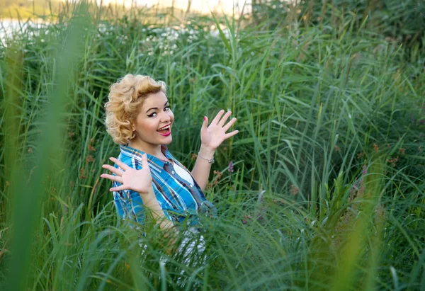 Beautiful happy surprised pinup girl in grass — Stock Photo, Image