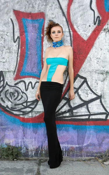 Futuristic woman with creative hairstyle near graffiti wall — Stock Photo, Image