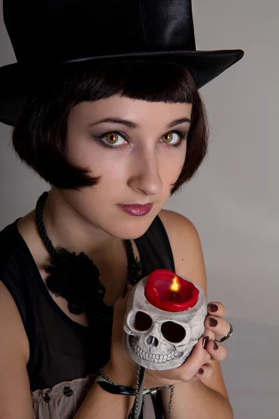 Witch with a skull in a black cylinder hat — Stock Photo, Image