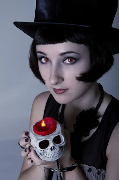 Vampire girl with a skull in a black cylinder hat — Stock Photo, Image