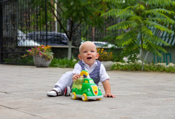 Menino sorrindo e brincando no carrinho de brinquedo — Fotografia de Stock