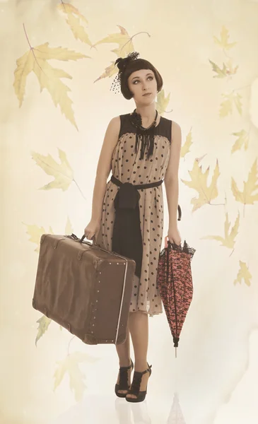 Красивая брюнетка с зонтиком и старым чемоданом — стоковое фото