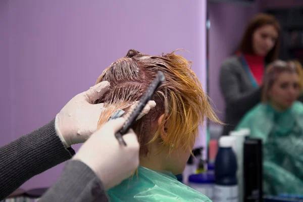 Косметик наносит цвет волос на женщину в гостиной — стоковое фото