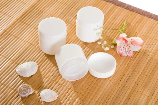 Frascos de crema vacíos en estera de bambú —  Fotos de Stock