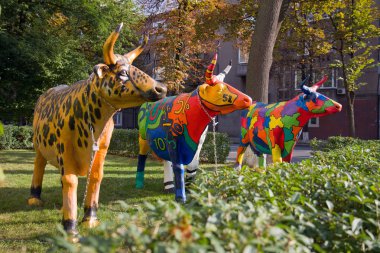 Üç komik boyalı plastik inekler