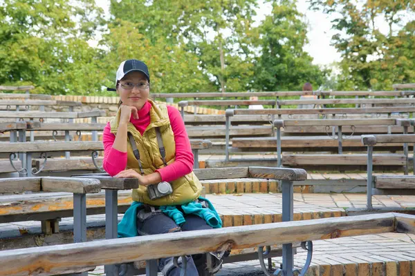 Beautiful asian tourist woman sitting on a bench — Stock Photo, Image