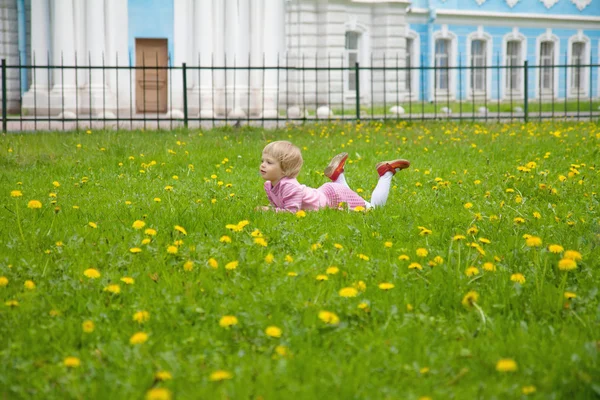 Little girl lying on the lawn — Stock Photo, Image