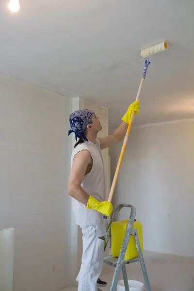 Young man painting ceiling with painting roller — Stock Photo, Image