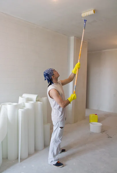 Worker painting ceiling with painting roller — Stock Photo, Image