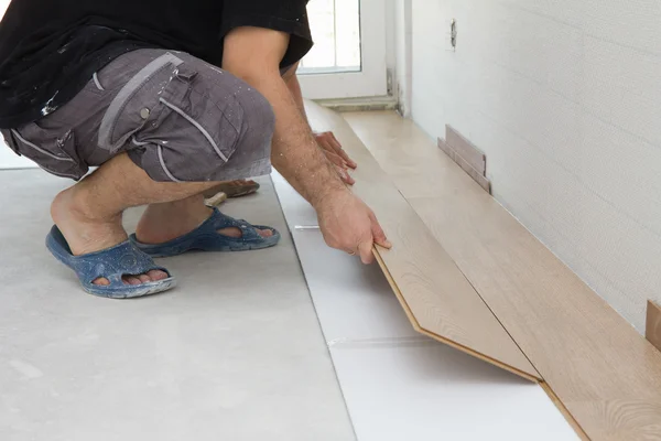 Worker assembling laminate floor — Stock Photo, Image