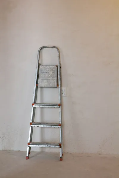 Ступенчатая лестница возле гипсовой стены — стоковое фото