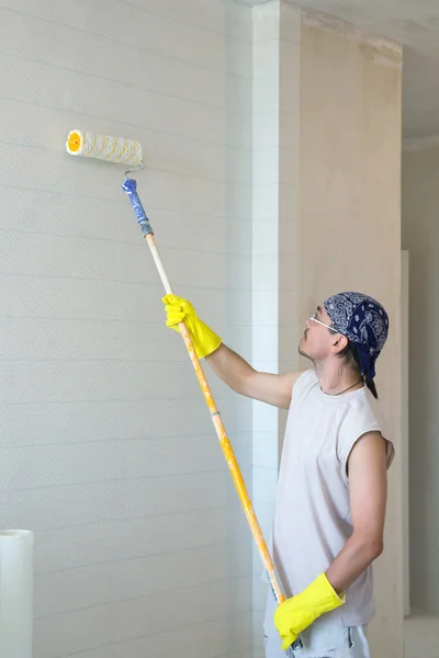 Young man painting wallpaper — Stock Photo, Image