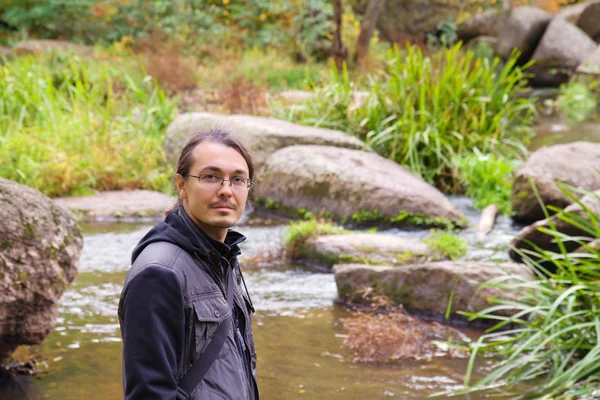 Nehri ile sonbahar ormanın tadını çıkarıyor adam — Stok fotoğraf