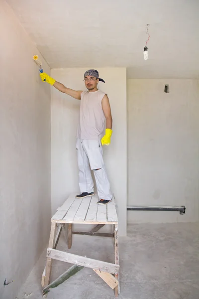 Pared de pintura de trabajador con rodillo de pintura — Foto de Stock