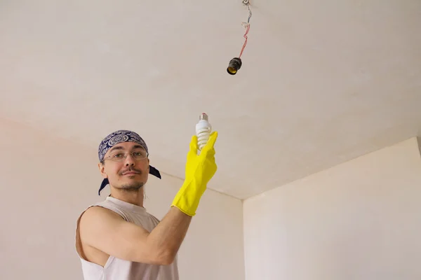 Electrician fixing ceiling light — Stock Photo, Image