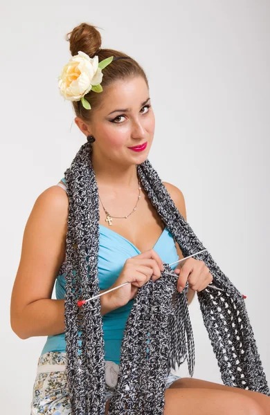 Joven pinup mujer tejiendo una bufanda — Foto de Stock