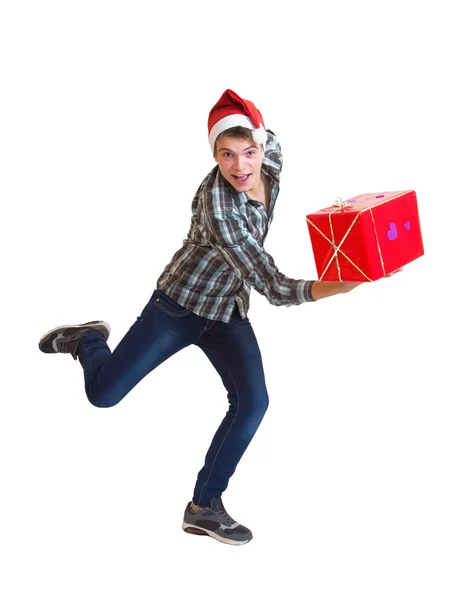 Teeager in Santa hat running with a gift — Stock Photo, Image