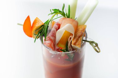 Kokteyl bardağının üstünde küçük bir aperatifle ilginç dekorasyonlu Bloody Mary, tazelik içeceği.