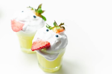 Süslü bardakta yumurta likörü. Krem şanti ve çilek parçalarıyla süslenmiş. Komik bir şekilde servis ediliyor.