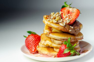 Muz, çilek ve fındık dolu krepler, üstüne çikolata ve çilek sosu, tatlı kahvaltı.