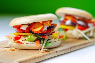 Izgara tavuk, marul, biber ve domatesli New York simidi sarımsak soslu lezzetli bir sandviç.