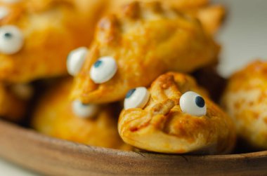 Süslü gözlerle mini börekler, leziz domuz eti, hindi, domuz pastırması ve yaban mersini, hepsi kısa hamura sarılmış, komik yiyecekler.