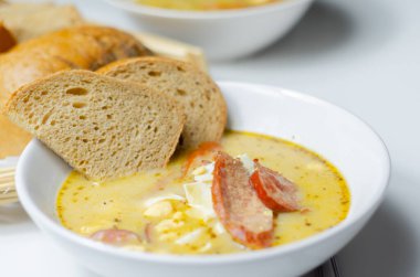 Geleneksel Polonya ekşi çorbası, sosis ve yumurtalar seramik kasede, Doğu Avrupa yemeği.