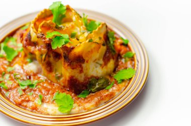 Dört peynirli ravioli makarna dilimlenmiş biftek, Chianti kırmızı şarap, sarımsak ve otlu ragu, ve üzerine pekorino peynirli ekmek kırıntısı ve taze maydanoz, ravioli tacıyla bitirilmiş beşamel sosu.