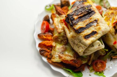 Izgara tortilla dürümü ve güney usulü tavuk göğsü. Karışık salatada servis edilen patates kızartması. Öğle yemeği vakti.