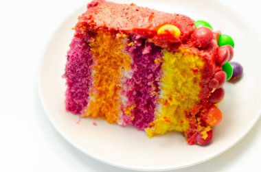 Gökkuşağı kutlama pastası, kremayla kaplanmış renkli sünger pastası ve gevrek bir şeker kabuğunda meyveli turta ile süslenmiş meyveli şekerle süslenmiş el pastası.