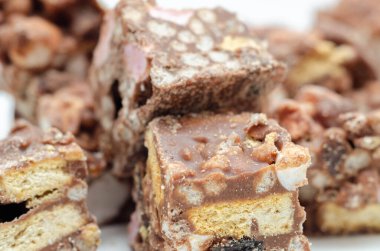 Sütlü çikolata kaplı harika bir karışım, şekerleme, bisküvi parçaları, çıtır pilav ve kirazlar, mini kayalık yol ısırıkları.