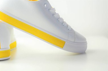 Sarı aksanlı beyaz spor ayakkabılar, klasik spor ayakkabılar.