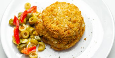 Morina ve karides kırmızı Tayland usulü balık keki turşulu zeytin, turşu, sarımsak ve kırmızı biber ile servis edilir.