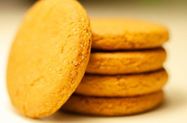 Beyaz arka planda bir yığın tarçınlı yulaflı kurabiyeye yaklaş, lezzetli ve sağlıklı bir atıştırmalık.