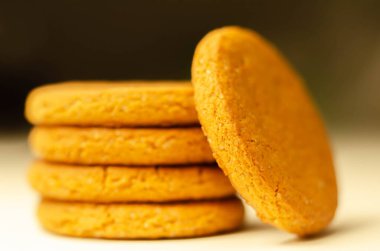 Beyaz arka planda bir yığın tarçınlı yulaflı kurabiyeye yaklaş, lezzetli ve sağlıklı bir atıştırmalık.