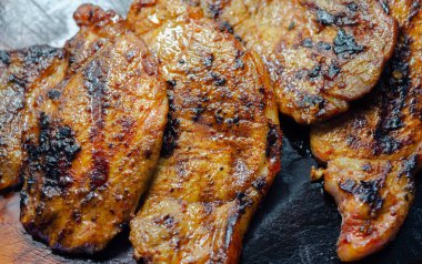 Taze ve sulu domuz filetosu biftekler, ahşap tahtada ızgara etler, iyi pişmiş biftekler.