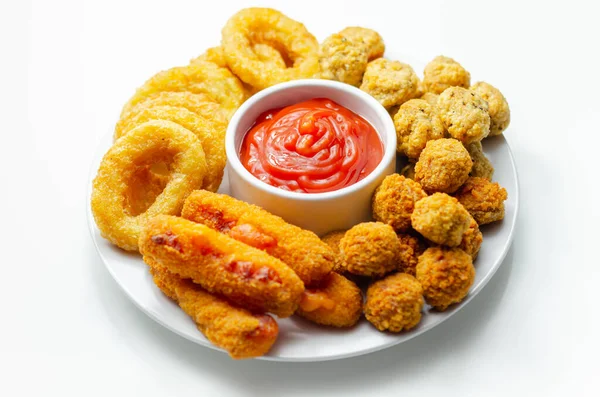 Güney usulü kızarmış tavuk, soğan halkaları ve mozzarella çubuğu beyaz tabakta domates sosu ve parti yemeği ile servis edilir.