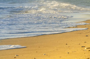 Kumsaldaki kumu etkileyen deniz suyuna bak, kumdaki deniz dalgaları sakince akıyor, dinlenme zamanı.