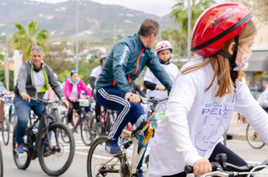 NERJA, SPAIN - 28 Şubat 2022 İspanyol Bisiklet Günü, bisiklet sürerken vatandaşların sağlıklı bir yaşam tarzını teşvik etmek, aileyle aktif bir gün