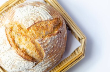 Geleneksel yuvarlak ekmek somunu klasik bir tarifle pişirilir, hasır sepette servis edilir, fırında.